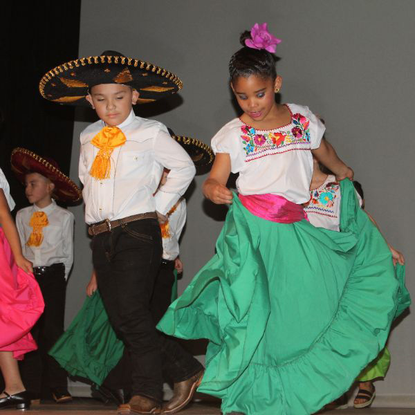  Students dancing and dressed in clothing unique to Mexico