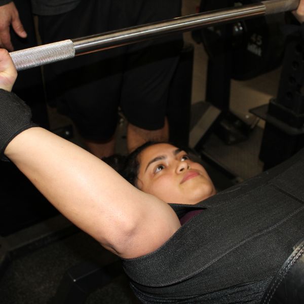  girl bench pressing a weight